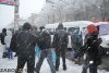 Снег и люди на остановке траспорта в Запорожье